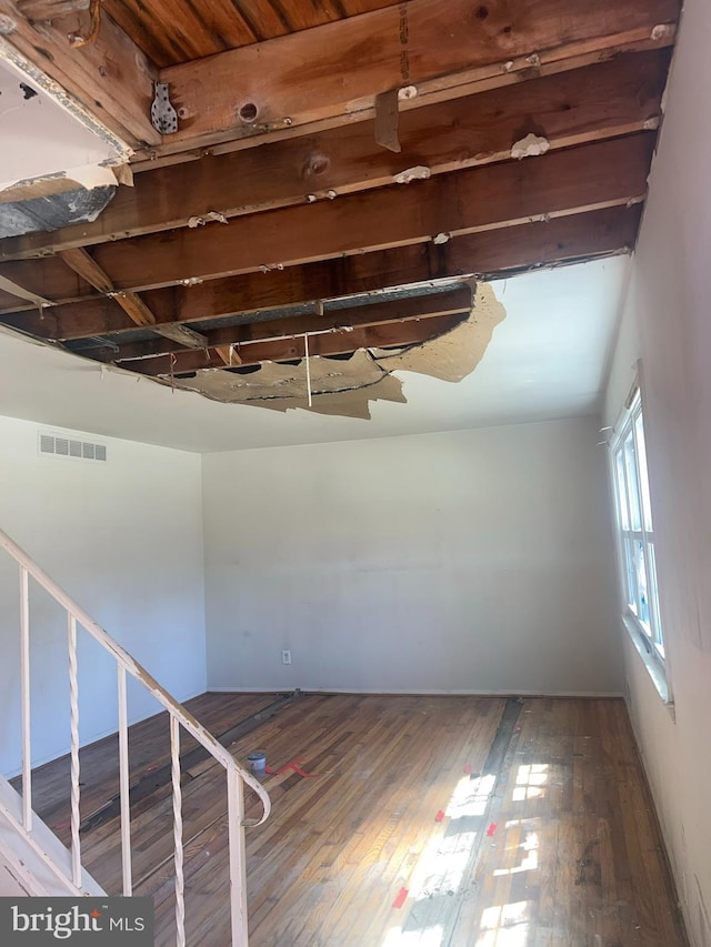 empty room with visible vents and hardwood / wood-style floors