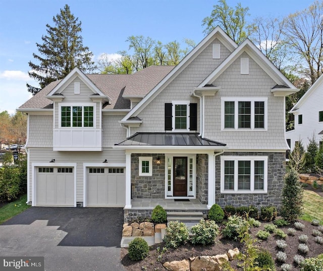 view of front facade with an attached garage, aphalt driveway, stone siding, a standing seam roof, and a porch