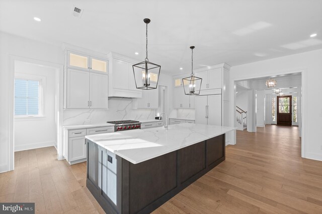 kitchen with an inviting chandelier, white cabinets, light wood finished floors, and recessed lighting