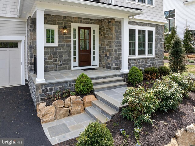 property entrance featuring driveway and stone siding