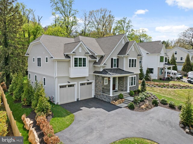 shingle-style home with roof with shingles, stone siding, a garage, aphalt driveway, and a standing seam roof
