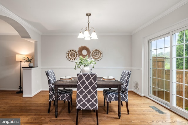 2192 Golf Course Dr, Reston, VA 20191 - dining space with a chandelier, ornamental molding, wood finished floors, baseboards, and arched walkways