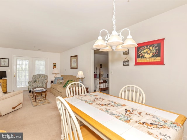 dining space with carpet and a notable chandelier