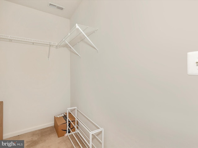 walk in closet featuring light carpet and visible vents