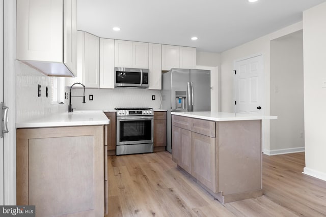 183 Mccormick Blvd, Newark, DE 19702 - kitchen with stainless steel appliances, light wood finished floors, tasteful backsplash, white cabinets, and recessed lighting