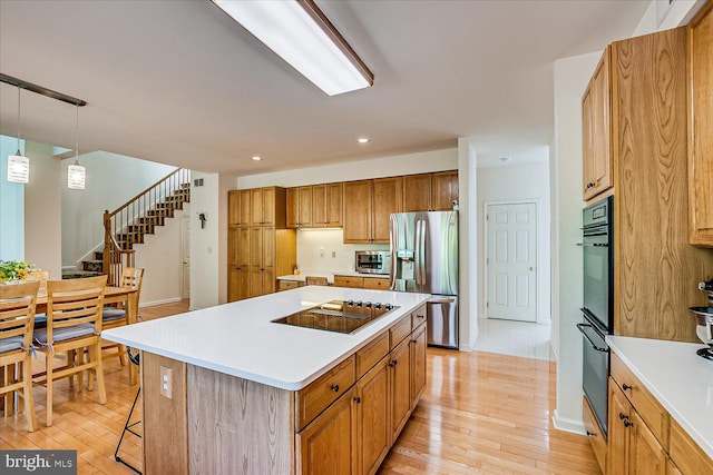 30 Revere Ct, Princeton Junction, NJ 08550 - kitchen featuring black appliances, light wood-type flooring, a center island, light countertops, and recessed lighting