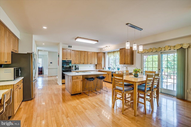 30 Revere Ct, Princeton Junction, NJ 08550 - kitchen featuring black appliances, light countertops, light wood-style flooring, a center island, and recessed lighting