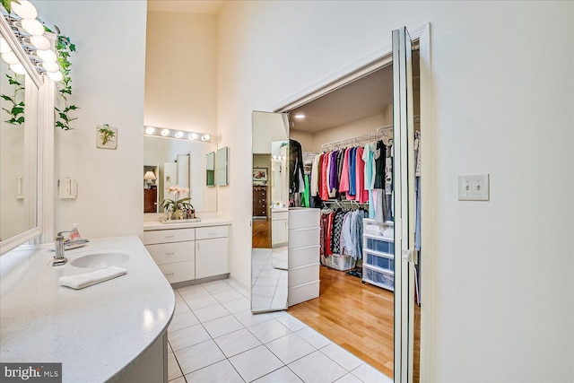 30 Revere Ct, Princeton Junction, NJ 08550 - bathroom featuring tile patterned floors, two vanities, a spacious closet, and a towering ceiling
