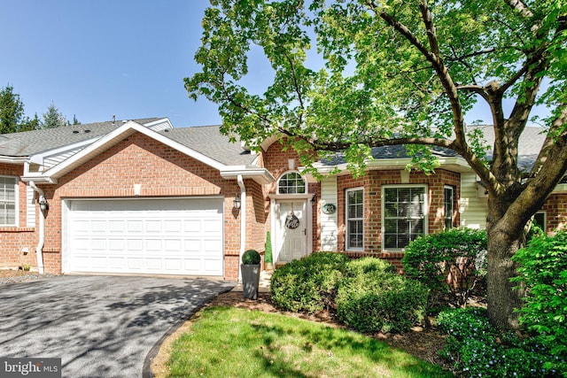 view of front of house featuring brick siding, a garage, and aphalt driveway