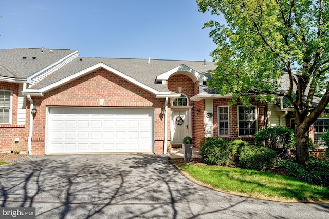 view of front of property featuring roof with shingles, an attached garage, driveway, and brick siding