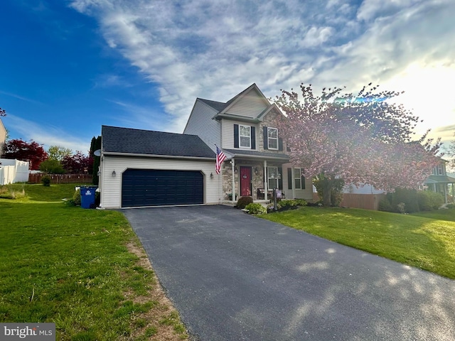 traditional-style house featuring a garage, a front lawn, aphalt driveway, and covered porch