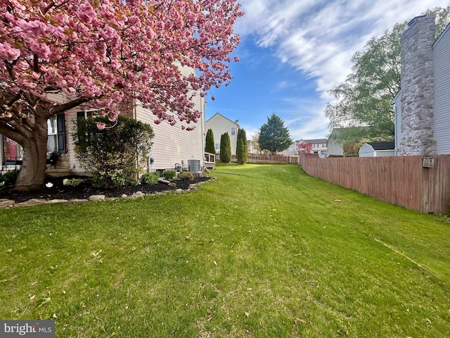 view of yard with fence and cooling unit