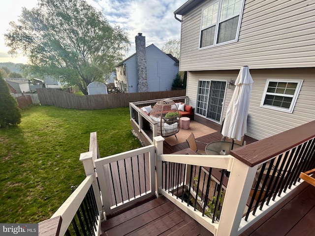deck featuring a fenced backyard, an outdoor hangout area, and a lawn