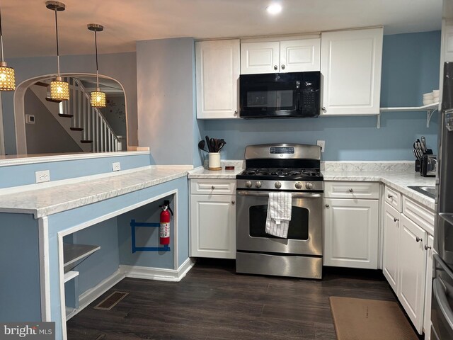 kitchen featuring stainless steel gas range, black microwave, arched walkways, white cabinetry, and visible vents
