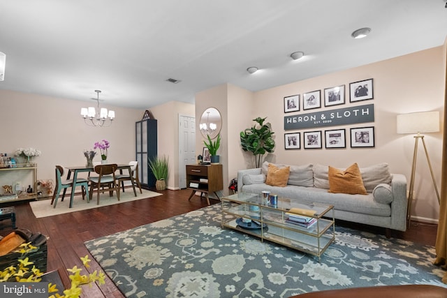 living room featuring wood-type flooring, a chandelier, and visible vents