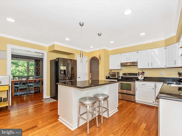 7915 Mount Pleasant Ct E, Walkersville, MD 21793 - kitchen featuring dark countertops, under cabinet range hood, white cabinets, light wood finished floors, and appliances with stainless steel finishes
