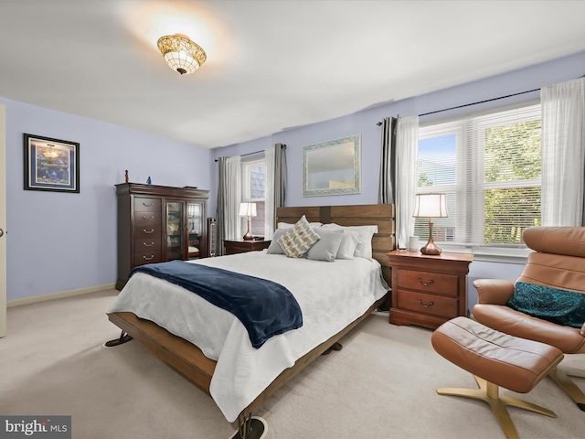 bedroom with multiple windows and light carpet