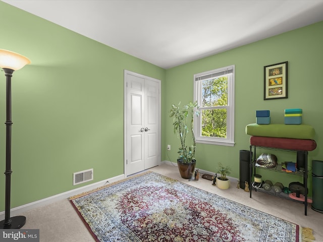 sitting room with baseboards, visible vents, and carpet