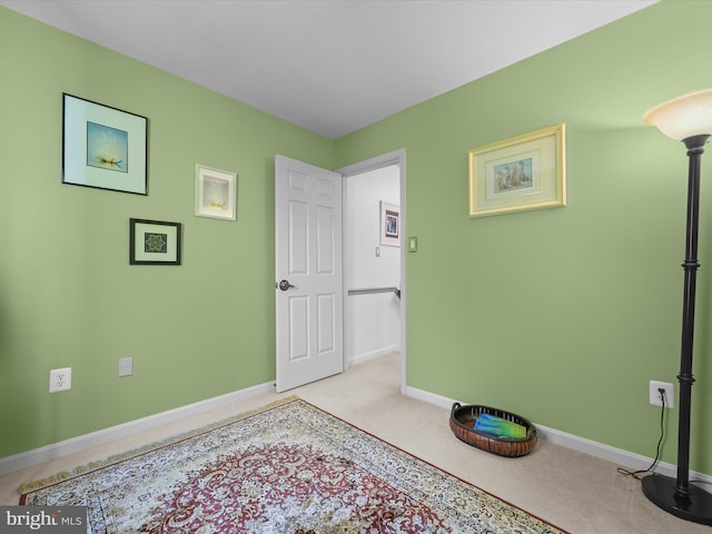 bedroom featuring baseboards and light colored carpet