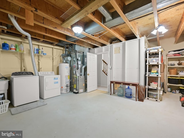 unfinished below grade area featuring heating unit, washer and clothes dryer, stairway, and gas water heater