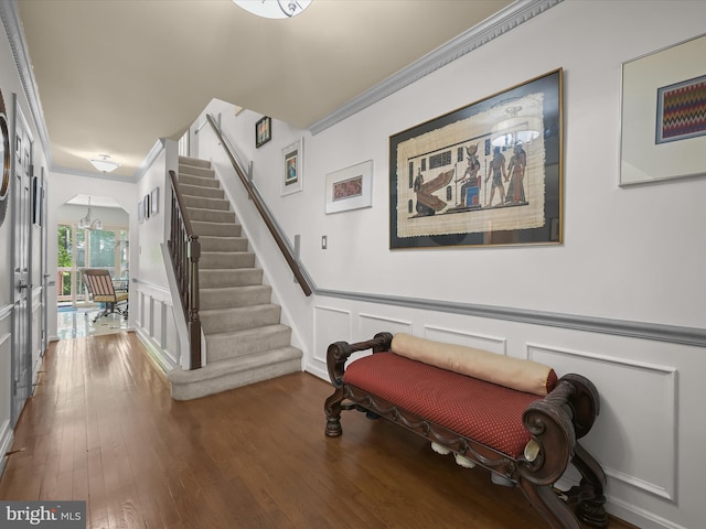 stairs featuring arched walkways, ornamental molding, and a decorative wall