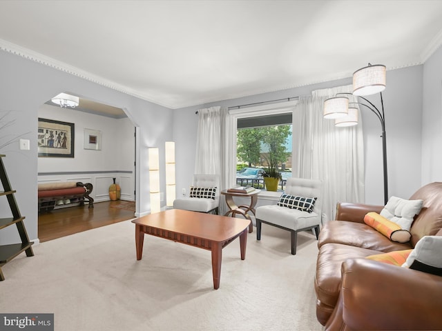 living room featuring ornamental molding, arched walkways, and wood finished floors