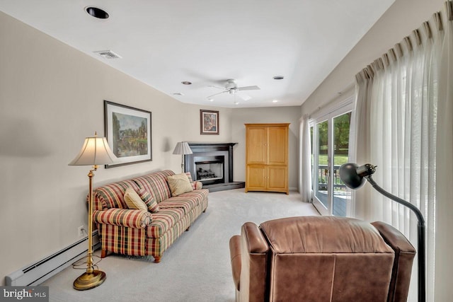 living area featuring a ceiling fan, light colored carpet, a fireplace with raised hearth, a baseboard heating unit, and recessed lighting