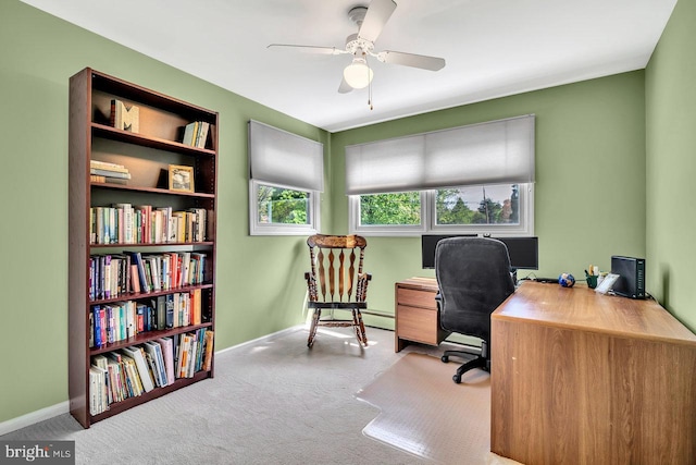 carpeted office space featuring baseboards and ceiling fan