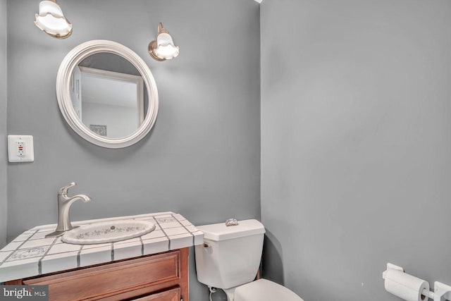 half bathroom with vanity and toilet