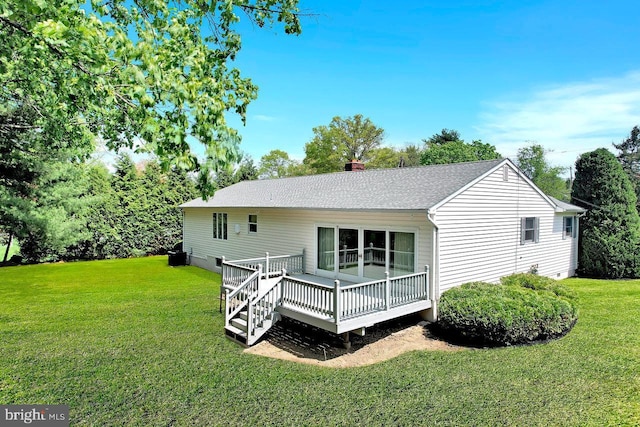 back of house with a lawn, a shingled roof, a chimney, and a deck