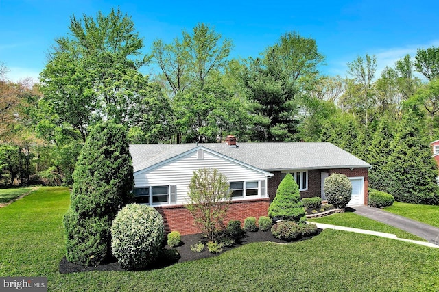 ranch-style home featuring brick siding, a garage, and a front yard