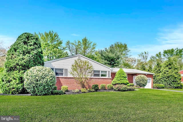 view of front of home featuring brick siding, a front lawn, and an attached garage