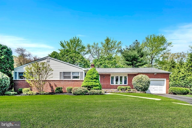 ranch-style home featuring a chimney, a garage, brick siding, aphalt driveway, and a front lawn