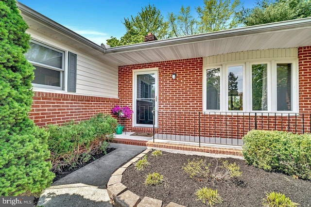entrance to property with brick siding and a chimney