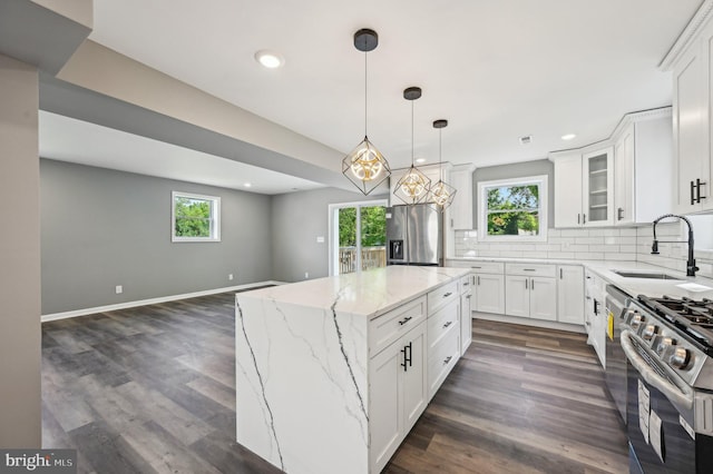 1954 Sponson St, Baltimore, MD 21230 - kitchen with a sink, stainless steel appliances, backsplash, white cabinets, and a kitchen island