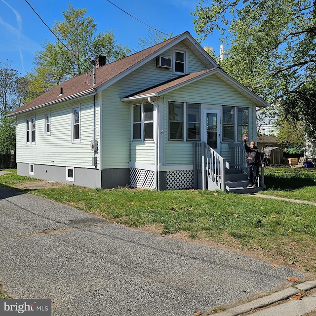 bungalow-style home with a sunroom and a front lawn