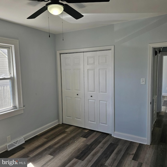 unfurnished bedroom with a ceiling fan, visible vents, baseboards, a closet, and dark wood-type flooring