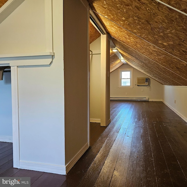 additional living space with vaulted ceiling, a wall mounted air conditioner, baseboards, a baseboard radiator, and dark wood-type flooring