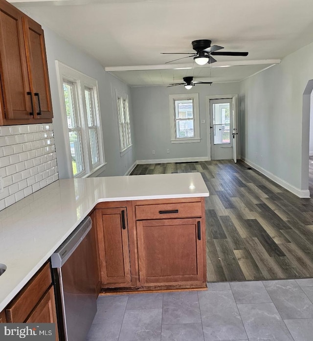 kitchen with a peninsula, open floor plan, a ceiling fan, backsplash, and stainless steel dishwasher