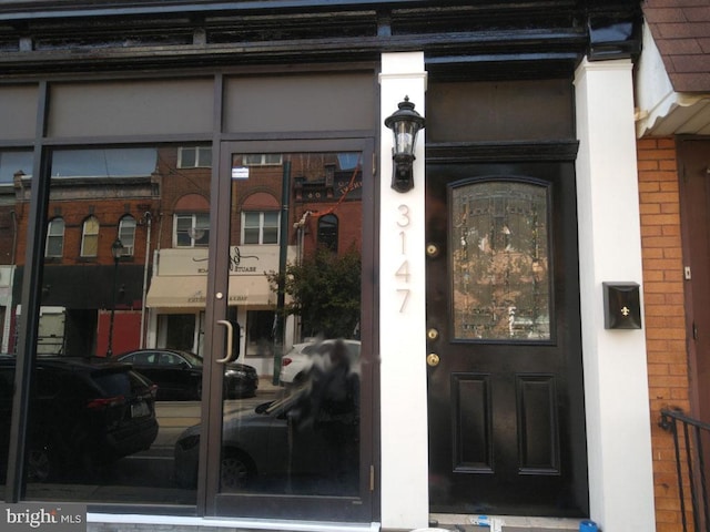entrance to property featuring brick siding