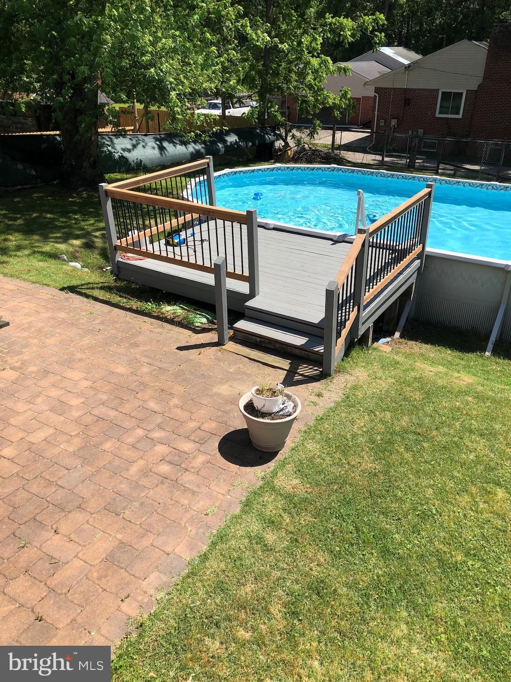pool featuring a yard, fence, and a wooden deck