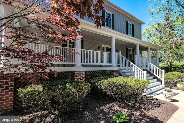 farmhouse-style home with a porch and stairway