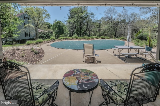 view of swimming pool featuring a patio and a covered pool