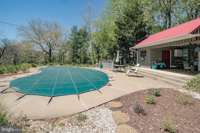 view of swimming pool with a covered pool and a patio area