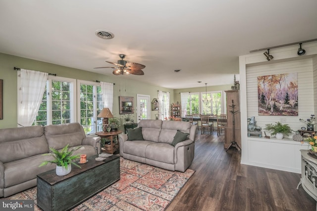 living area with dark wood-style flooring, ceiling fan, visible vents, and track lighting
