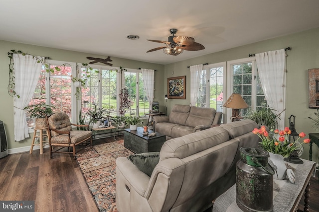 living area featuring a ceiling fan, visible vents, plenty of natural light, and wood finished floors