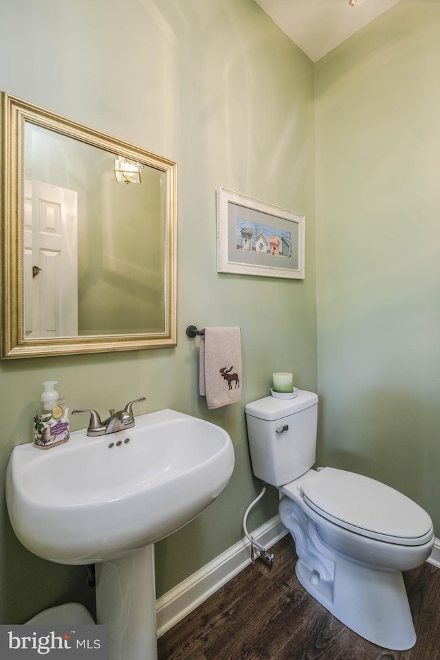 bathroom featuring baseboards, toilet, and wood finished floors