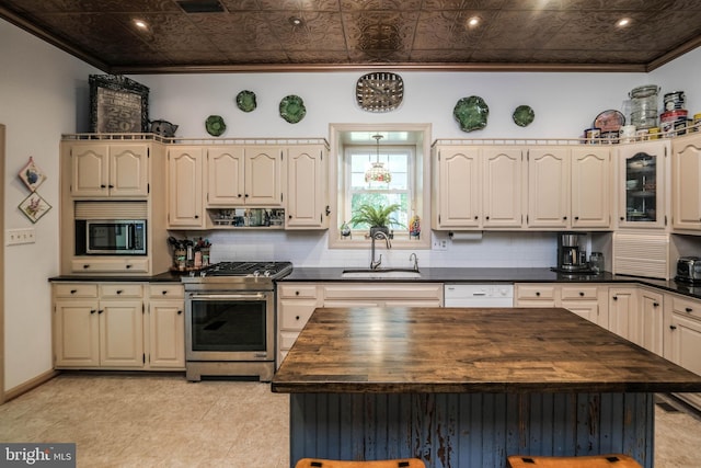 kitchen featuring a sink, crown molding, stainless steel range with gas cooktop, and butcher block counters