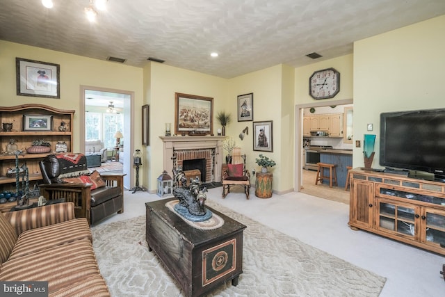 living area with recessed lighting, light colored carpet, visible vents, and a fireplace