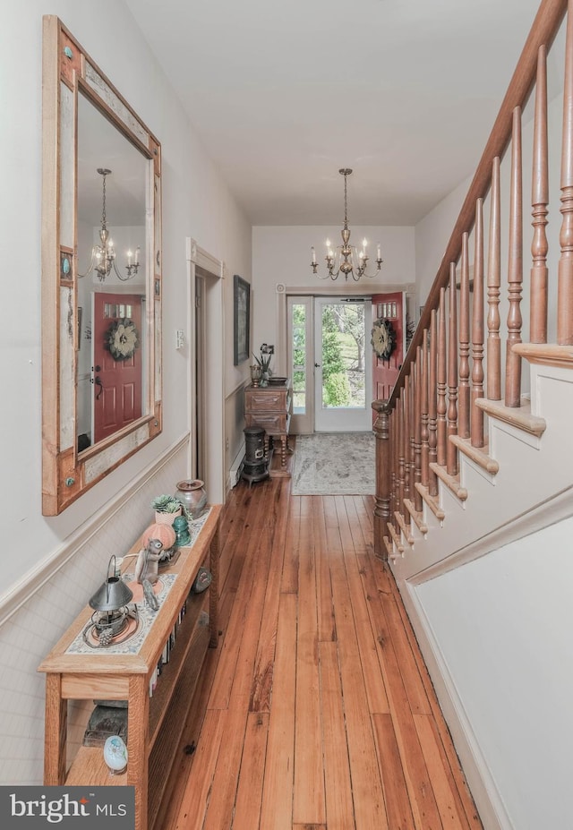 foyer entrance featuring stairs, a chandelier, and hardwood / wood-style flooring